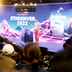 Vitalik Buterin stands on stage in a grey t-shirt and red pants with the words ETHDENVER 2022 behind him. A crowd watches him speak without much fanfare.